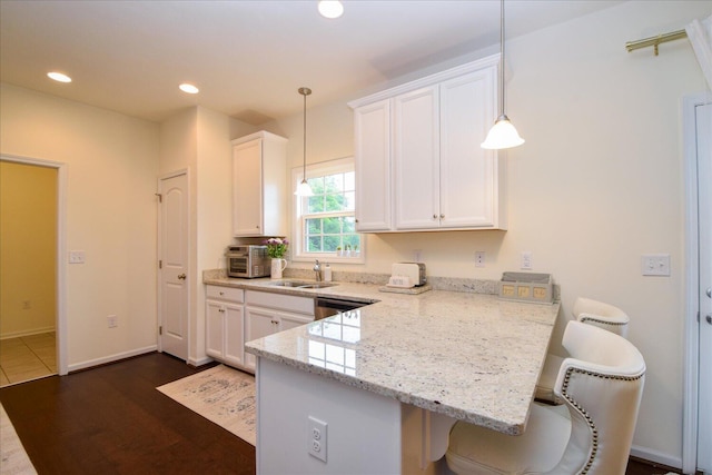 8322 Leighburn Dr, Roanoke, VA 24019 - kitchen with white cabinetry, a peninsula, light stone countertops, a kitchen bar, and recessed lighting