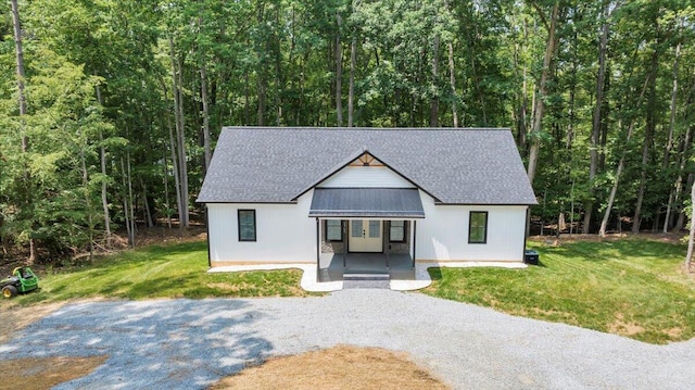 2365 Lakewood Forest Rd, Moneta, VA 24121 - view of front of home with covered porch, gravel driveway, a wooded view, and a front lawn