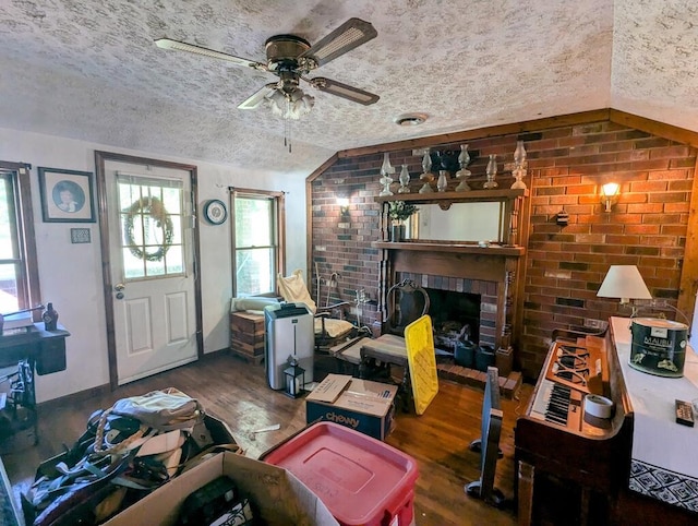 606 Haycock Rd SE, Floyd, VA 24091 - living area featuring a textured ceiling, wood finished floors, a ceiling fan, brick wall, and a fireplace