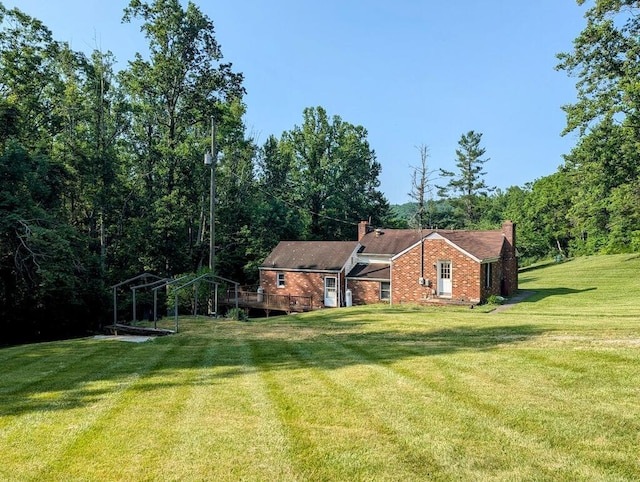 606 Haycock Rd SE, Floyd, VA 24091 - view of side of home featuring a chimney, brick siding, a yard, a deck, and a wooded view