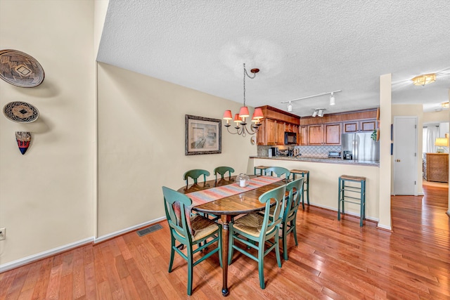 1230 Nature Ln Unit 1, Union Hall, VA 24176 - dining space featuring a chandelier, light wood finished floors, a textured ceiling, and track lighting
