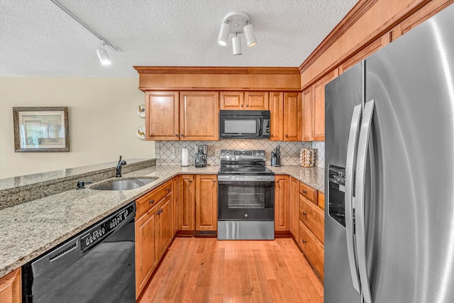 1230 Nature Ln Unit 1, Union Hall, VA 24176 - kitchen with black appliances, a textured ceiling, brown cabinets, light wood finished floors, and light stone counters