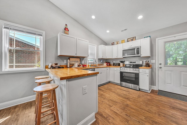 2027 Clinton Ave SE, Roanoke, VA 24013 - kitchen with appliances with stainless steel finishes, a peninsula, vaulted ceiling, healthy amount of natural light, and a breakfast bar