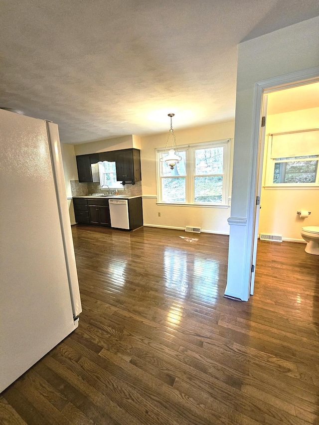 2633 Wood Warbler Ln, Roanoke, VA 24018 - kitchen with white appliances, dark wood-type flooring, light countertops, pendant lighting, and backsplash