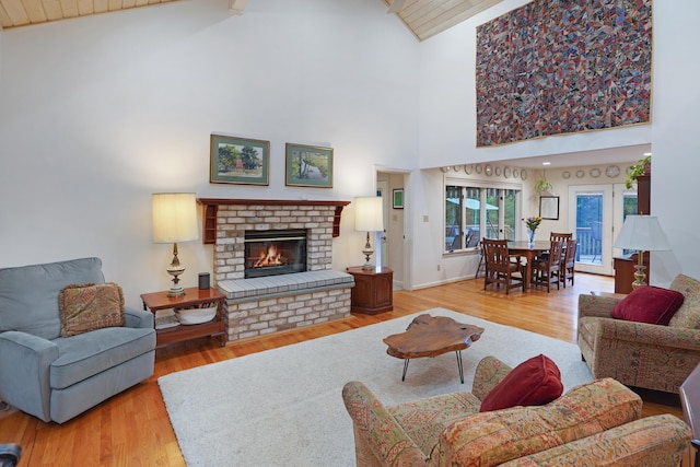 126 Windmere Trl, Moneta, VA 24121 - living area featuring high vaulted ceiling, a brick fireplace, wood finished floors, and beam ceiling