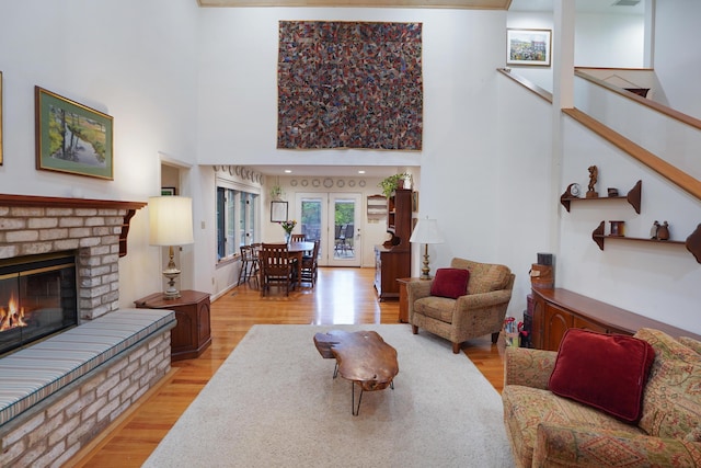126 Windmere Trl, Moneta, VA 24121 - living area featuring wood finished floors, a brick fireplace, a high ceiling, and french doors