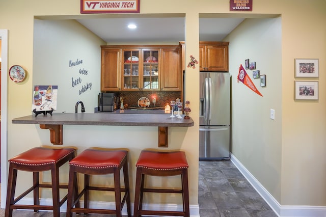414 Augusta Way, Wirtz, VA 24184 - kitchen featuring stainless steel fridge with ice dispenser, a kitchen bar, backsplash, dark countertops, and brown cabinetry