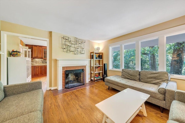 2702 Yellow Mountain Rd SE, Roanoke, VA 24014 - living room with healthy amount of natural light, light wood-style floors, and a brick fireplace