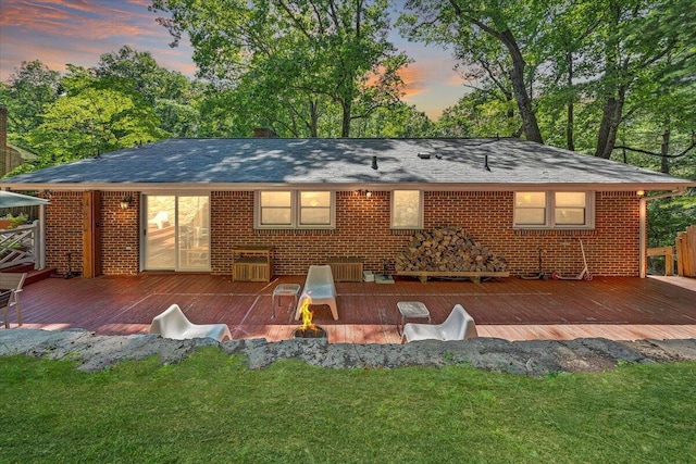 2702 Yellow Mountain Rd SE, Roanoke, VA 24014 - back of property at dusk featuring a wooden deck, brick siding, and a yard