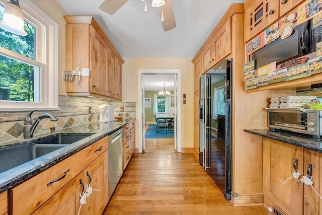 2702 Yellow Mountain Rd SE, Roanoke, VA 24014 - kitchen with black refrigerator with ice dispenser, stainless steel dishwasher, light wood-style floors, backsplash, and dark stone counters