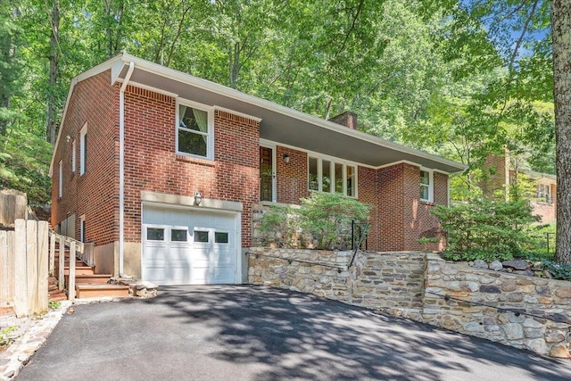 2702 Yellow Mountain Rd SE, Roanoke, VA 24014 - view of front of home with asphalt driveway, brick siding, an attached garage, and a chimney