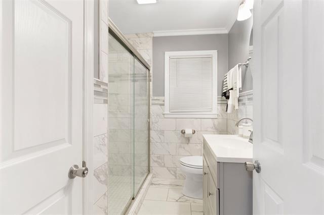3325 Fleetwood Ave SW, Roanoke, VA 24015 - full bath with vanity, a stall shower, marble look tiles, crown molding, and tile walls