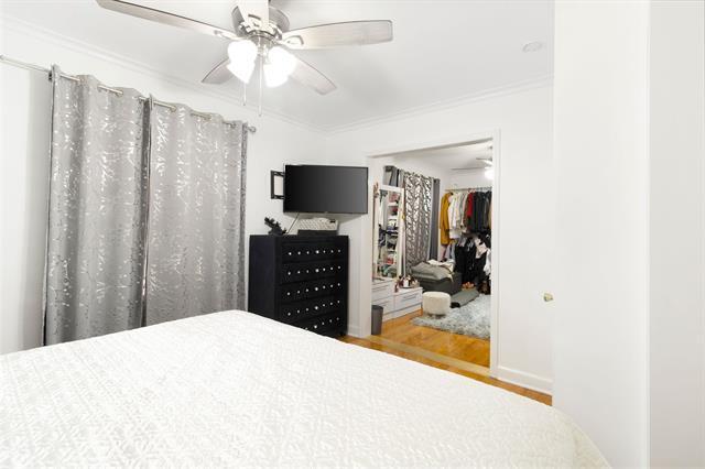 3325 Fleetwood Ave SW, Roanoke, VA 24015 - bedroom featuring wood finished floors, crown molding, a walk in closet, and a ceiling fan