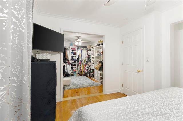 3325 Fleetwood Ave SW, Roanoke, VA 24015 - bedroom featuring wood finished floors, a closet, a fireplace, ornamental molding, and ceiling fan