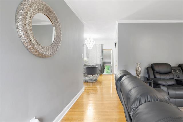 3325 Fleetwood Ave SW, Roanoke, VA 24015 - living room featuring crown molding, light wood-type flooring, and a chandelier