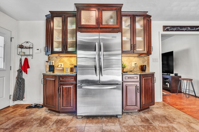 716 Arcadia Cir, Vinton, VA 24179 - kitchen featuring freestanding refrigerator, light stone counters, decorative backsplash, and glass insert cabinets