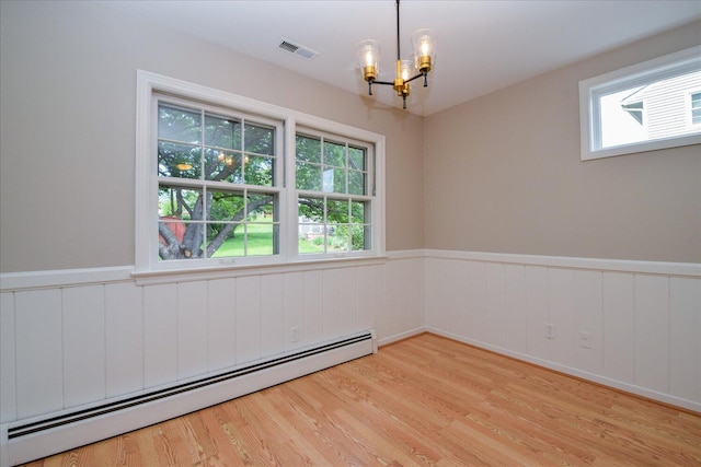 115 Bartley Dr, Salem, VA 24153 - spare room featuring a baseboard heating unit, a chandelier, wainscoting, light wood-style flooring, and healthy amount of natural light