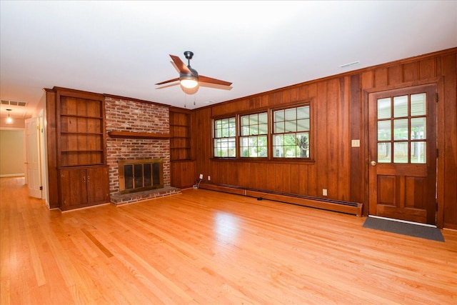 115 Bartley Dr, Salem, VA 24153 - unfurnished living room with a baseboard heating unit, light wood-type flooring, ceiling fan, a fireplace, and wood walls