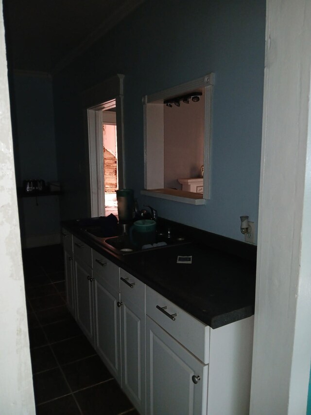 918 Dale Ave SE, Roanoke, VA 24013 - kitchen featuring dark countertops, dark tile patterned floors, ornamental molding, and white cabinets