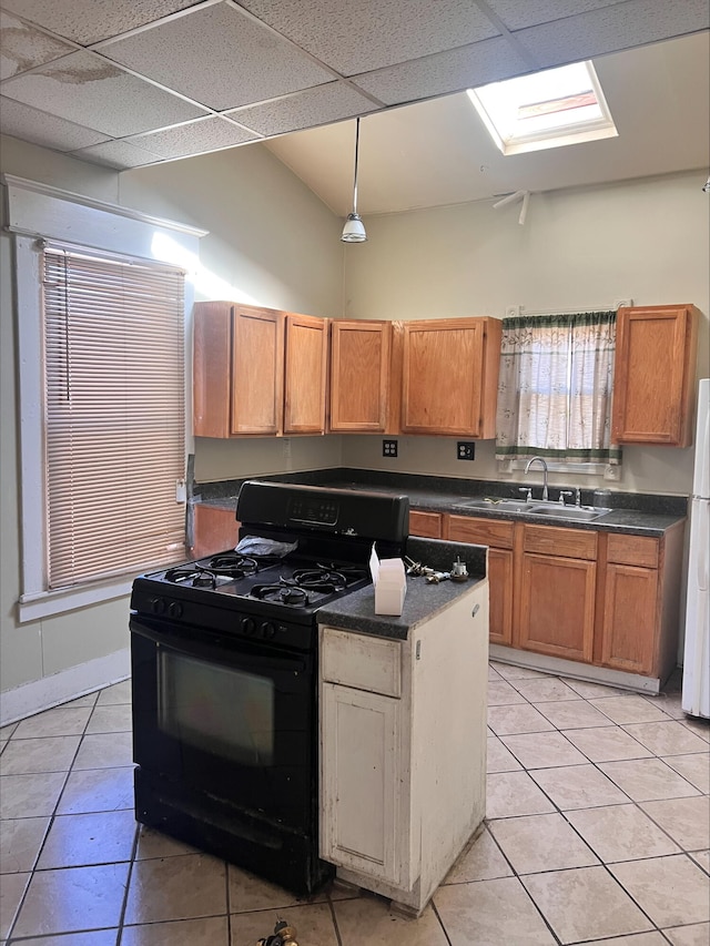 906 5th St SE, Roanoke, VA 24013 - kitchen with black range with gas cooktop, light tile patterned floors, freestanding refrigerator, and dark countertops