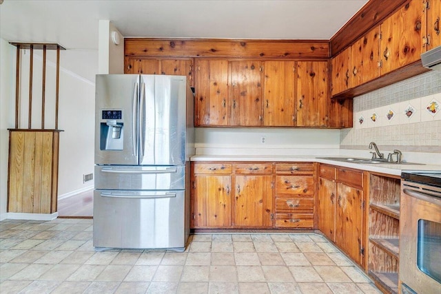 618 Gladies St NW, Roanoke, VA 24017 - kitchen featuring stainless steel fridge with ice dispenser, decorative backsplash, light countertops, stove, and brown cabinets