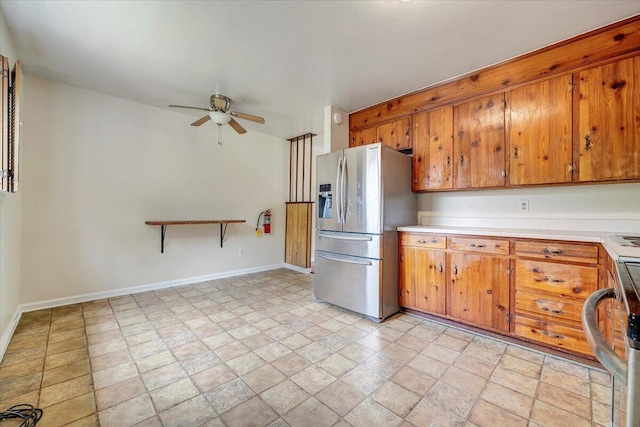 618 Gladies St NW, Roanoke, VA 24017 - kitchen featuring stainless steel fridge with ice dispenser, ceiling fan, brown cabinets, light countertops, and stone finish flooring