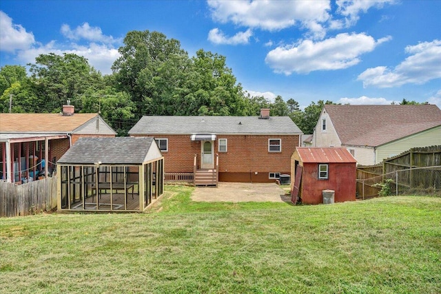 618 Gladies St NW, Roanoke, VA 24017 - rear view of property featuring a fenced backyard, a shed, a sunroom, a chimney, and brick siding