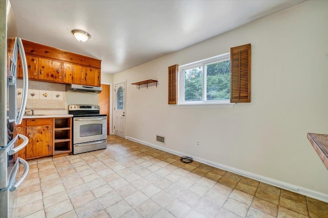 618 Gladies St NW, Roanoke, VA 24017 - kitchen with appliances with stainless steel finishes, under cabinet range hood, backsplash, brown cabinetry, and light countertops