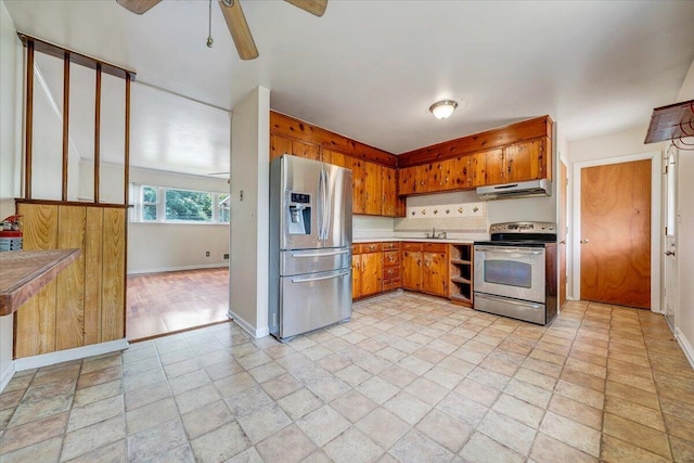 618 Gladies St NW, Roanoke, VA 24017 - kitchen with stainless steel appliances, under cabinet range hood, a ceiling fan, brown cabinets, and light countertops