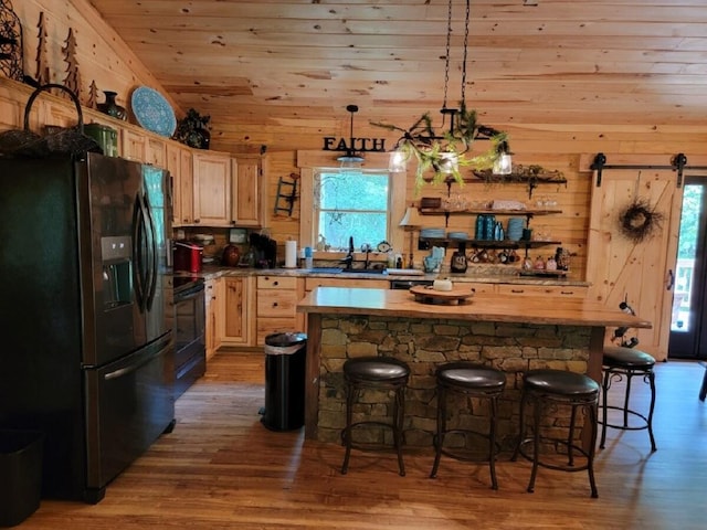 350 Sizer Ln, New Castle, VA 24127 - kitchen with black appliances, light brown cabinetry, wood finished floors, a kitchen bar, and a center island