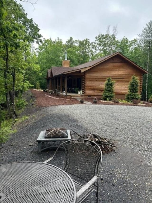 350 Sizer Ln, New Castle, VA 24127 - back of property featuring log siding, a fire pit, and a chimney