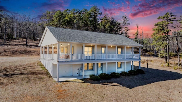 2534 Paris Mountain Rd, Elliston, VA 24087 - view of front facade featuring an attached garage, a balcony, dirt driveway, covered porch, and a shingled roof