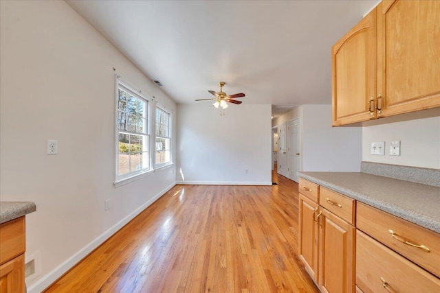 2534 Paris Mountain Rd, Elliston, VA 24087 - kitchen with light wood-type flooring, a ceiling fan, light countertops, and light brown cabinets