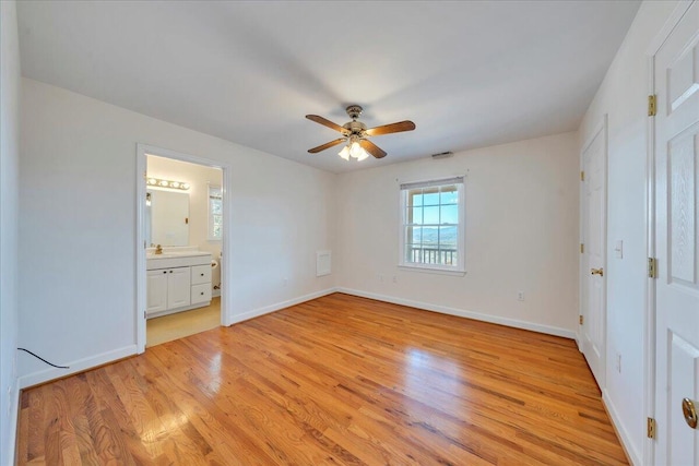 2534 Paris Mountain Rd, Elliston, VA 24087 - unfurnished bedroom with light wood-style floors, connected bathroom, and a ceiling fan