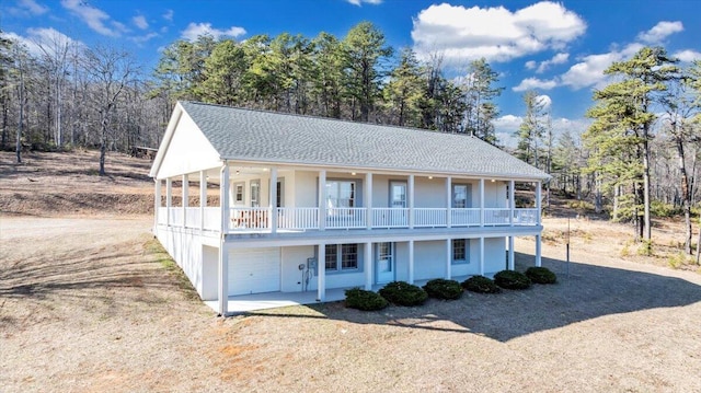 2534 Paris Mountain Rd, Elliston, VA 24087 - view of front of property featuring a garage, dirt driveway, a balcony, covered porch, and view of scattered trees