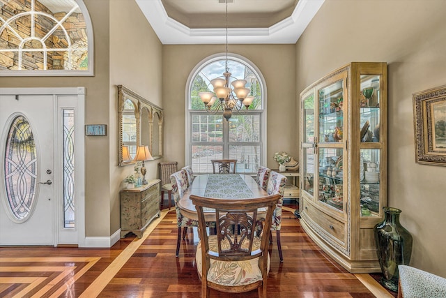 325 Bull Run Trl, Penhook, VA 24137 - dining space featuring a chandelier, dark wood-type flooring, a towering ceiling, a raised ceiling, and ornamental molding