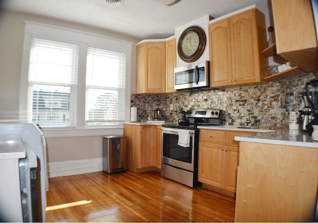 1138 Montrose Ave SE, Roanoke, VA 24013 - kitchen featuring stainless steel appliances, light wood-type flooring, tasteful backsplash, and light countertops