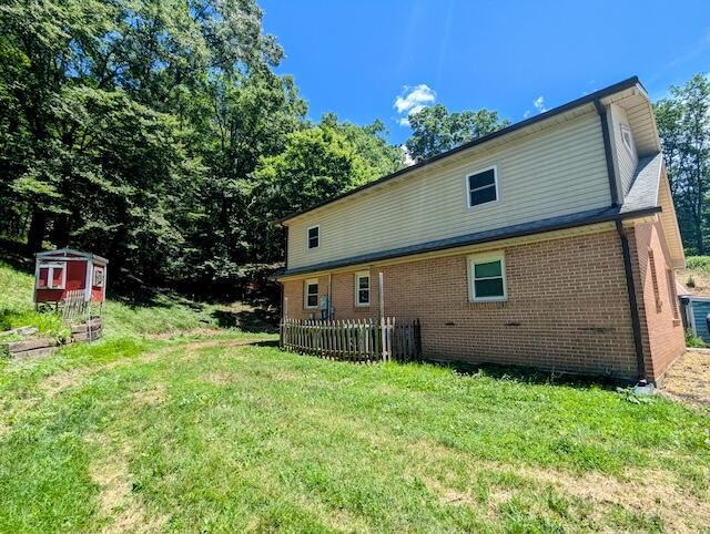 221 Camp Creek Rd NW, Riner, VA 24149 - back of house with brick siding and a lawn