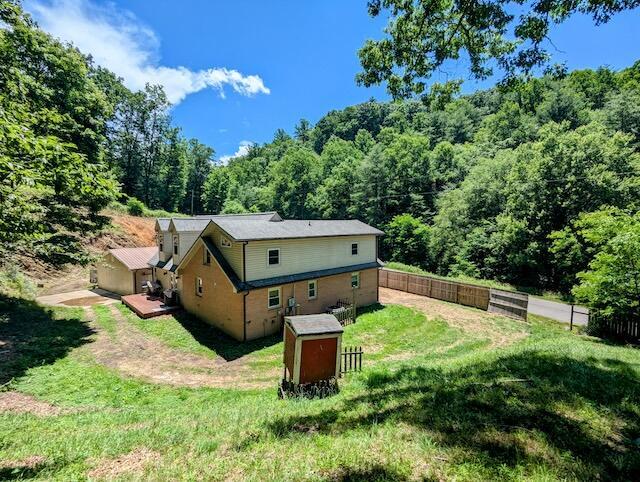 221 Camp Creek Rd NW, Riner, VA 24149 - back of property featuring a view of trees, a wooden deck, and a shed