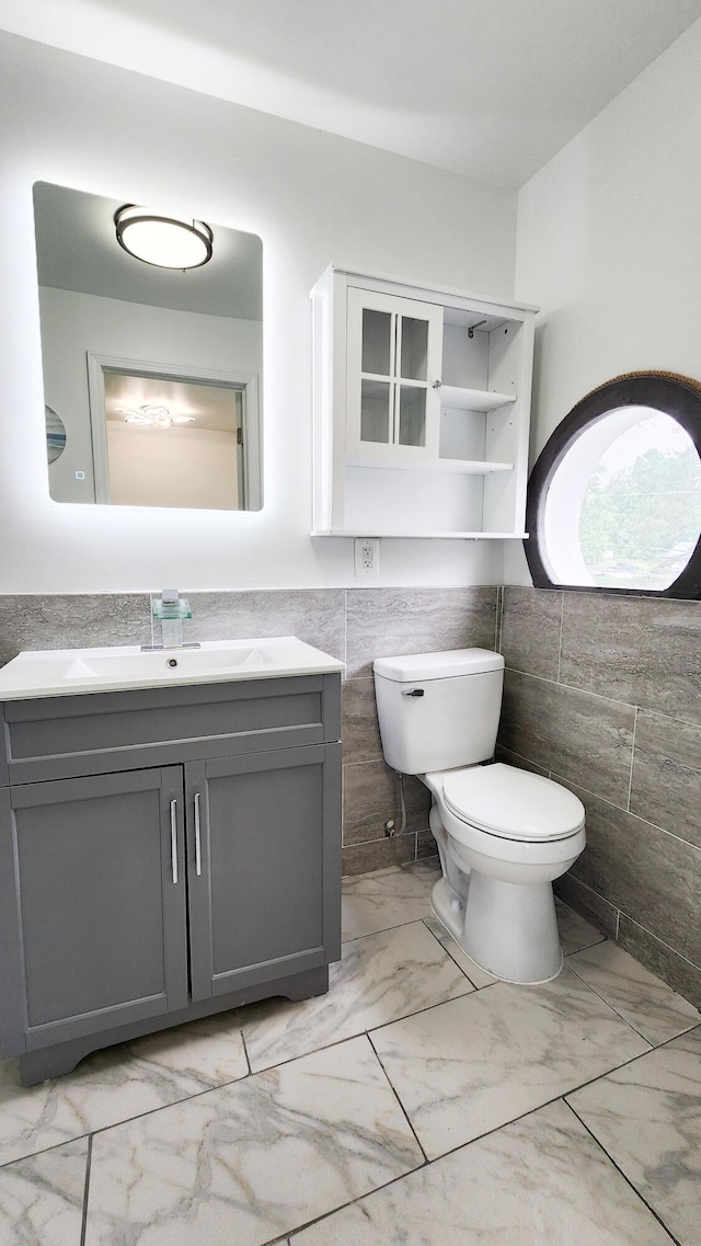 801 Concord St, Selma, VA 24474 - half bathroom featuring tile walls, marble finish floors, vanity, and wainscoting