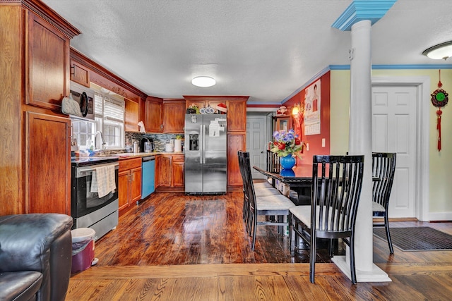 3653 Bunker Hill Dr, Roanoke, VA 24018 - kitchen with appliances with stainless steel finishes, ornate columns, dark wood finished floors, a textured ceiling, and decorative backsplash