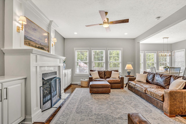 1258 Colby Dr, Forest, VA 24551 - living room with ceiling fan, a fireplace, a chandelier, a textured ceiling, and light wood-style floors
