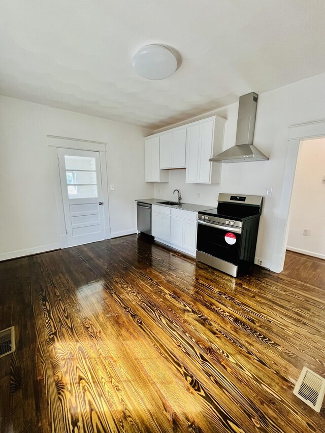 1138 Murray Ave SE, Roanoke, VA 24013 - kitchen with appliances with stainless steel finishes, wall chimney range hood, dark wood finished floors, and white cabinetry