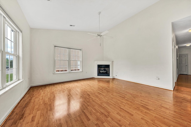 6617 Hartman Ct, Roanoke, VA 24019 - unfurnished living room with light wood-style floors, ceiling fan, a fireplace with raised hearth, and vaulted ceiling