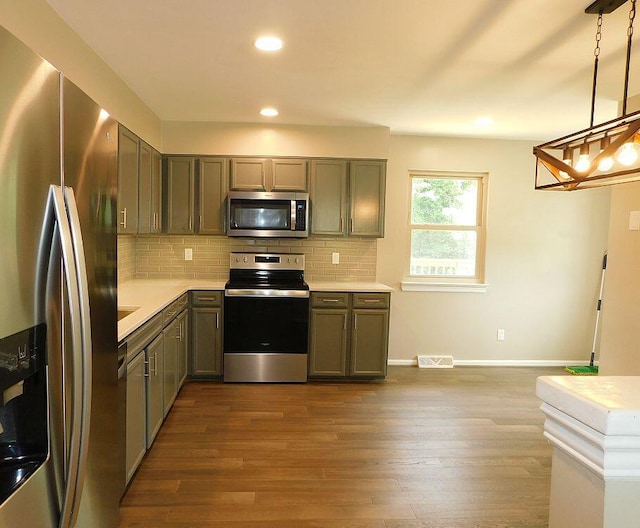 4230 Belford St SW, Roanoke, VA 24018 - kitchen with appliances with stainless steel finishes, light countertops, decorative backsplash, dark wood-style floors, and recessed lighting