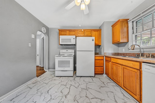 755 Brandon Ave SW, Roanoke, VA 24015 - kitchen with white appliances, light marble finish floors, a ceiling fan, brown cabinets, and arched walkways