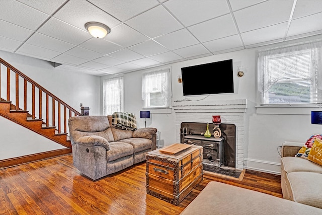 1831 S Carpenter Dr, Covington, VA 24426 - living room featuring wood finished floors, stairs, a paneled ceiling, and a brick fireplace