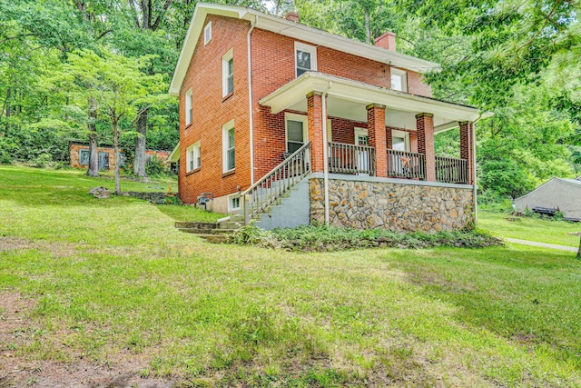 1831 S Carpenter Dr, Covington, VA 24426 - view of front of property with a chimney, brick siding, a porch, and a front lawn