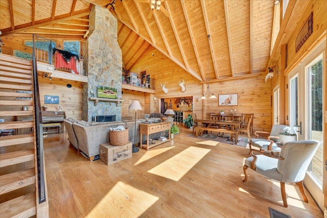 1769 Scenic View Rd, Moneta, VA 24121 - living area with a wood ceiling with exposed beams, wood walls, wood finished floors, high vaulted ceiling, and a stone fireplace