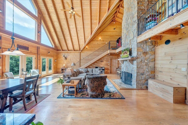 1769 Scenic View Rd, Moneta, VA 24121 - living room featuring high vaulted ceiling, a wooden ceiling with exposed beams, wood walls, a stone fireplace, and wood finished floors
